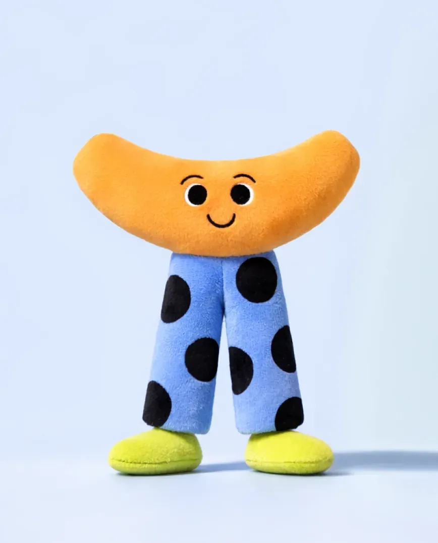 Nomie character as a plush figure with polka-dot legs