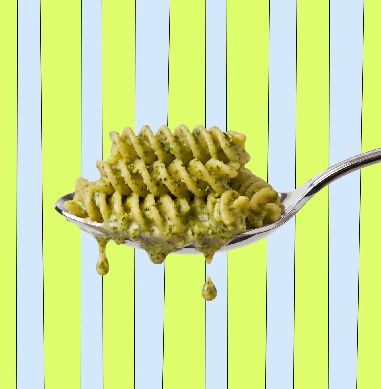 Spoon of Nomie pesto pasta on a striped background